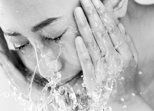 Woman washing her face after a revitalizing peel