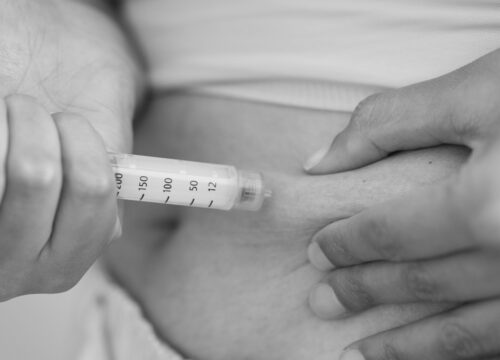Photo of a woman giving herself semaglutide injections